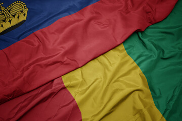 waving colorful flag of guinea and national flag of liechtenstein.