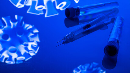 Vaccination viruses. Medical syringe with needle for protection flu virus and coronavirus. Covid immunization on blue. Close up vaccine vial dose flu shot drug needle syringe.