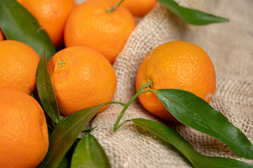 tangerines with leaves on a texture bag