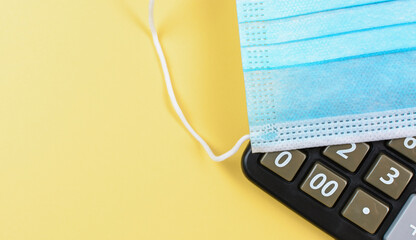 Medical mask on the calculator. Business and cost mask concept.