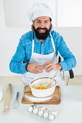 concept of housekeeping. making fresh dough. smiling bearded man wear chef hat. male cook preparing food in home kitchen. brutal hipster in apron cooking meal. time for eating. happy baking