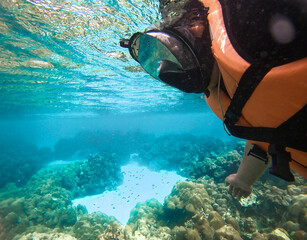 Man snorkelling underwater with snorkel mask.