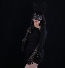 studio portrait of a beautiful girl with a theatrical mask on a black background