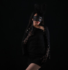 mysterious beautiful girl in a black venetian mask on a black background