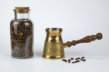 Turkish coffee pot with coffee beans in a jar, isolated on a white background