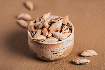 Pile of Almond nuts in a bowl on a white background. Fresh nuts in their shells.