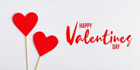 Red hearts of different sizes on a white background. Greeting card, lettering Happy Valentine's Day.