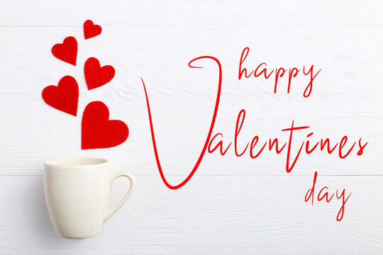 Red hearts coming out of the cup on white background. Concept greeting card, lettering Happy Valentine's Day.