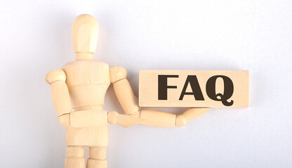 Wooden man shows with a hand to block with text FAQ
