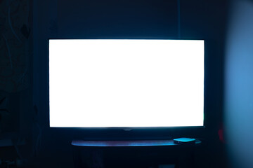 TV in a dark room with a white screen. 