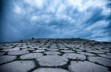Fototapeta premium Abandoned reservoir with dramatic dark clouds in the evening in Armenia, Kotayq