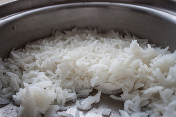 Jasmine cooked rice in white bowl and spoon on wooden background using as healthy food, thai food concept.