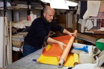 craftsman cutting leather with cutter  in workshop