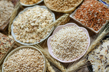 Closed up dry pearl barley seeds soft pink ceramic bowl with other natural cereal and grain seeds in dark tone