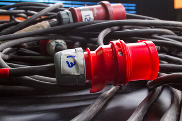 Red plastic professional power connector. High voltage power electric cable. Industrial power plug socket with cable.