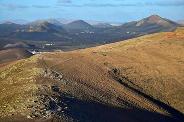 Beautiful volcanic landscape with a hiking trail in the evening sun. Lanzarote, Spain.