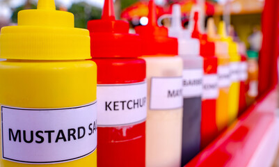Multiple flavor sauce bottles in a food card at a food festival. Different sauces in plastic