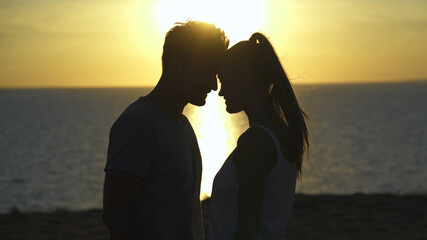 The romantic couple standing on the sea sunset