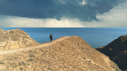 The man walking on the mountain against the beautiful sea view