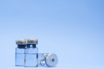 Ampoule, vial bottle on blue background. Vaccination concept, disease prevention. Health care,...
