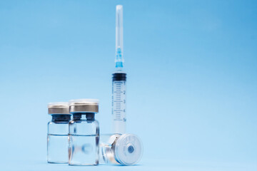 Ampoule, vial bottle, syringe on blue background. Vaccination concept, disease prevention. Health care, Coronavirus vaccine development