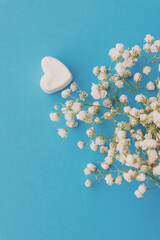 heart and white bouquet in a transparent vase on a blue background