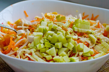 Fresh salad with cabbage, carrots and apple, close-up. Healthy food.