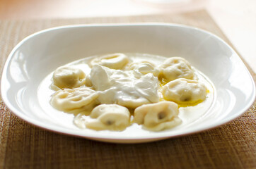 dumplings on a table with butter and sour cream. Close-up photo.