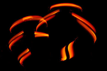 Light wave trail path, vibrant neon gold color in abstract swirls on a black background
