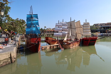 Fototapeta na wymiar Hoi An, Vietnam, January 16, 2021: Recreation of old boats for the Hoi An show anchored in the Thu Bon river