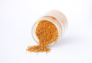 Bee pollen granules crumbled from glass jar
