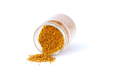 Bee pollen granules crumbled from glass jar