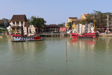 Hoi An, Vietnam, January 29, 2021: Old boats for the Hoi An show anchored in the Thu Bon river next to the famous Japanese Bridge
