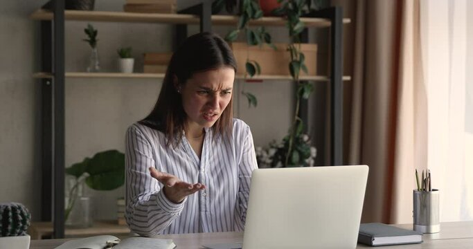 Unhappy young business lady looking at computer screen, feeling confused by failure. Frustrated millennial woman reading email with unpleasant news, stressed by mistake or having problem with device.