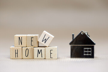 New Home text written with wooden cubes background with symbol of cozy little house with blurred...