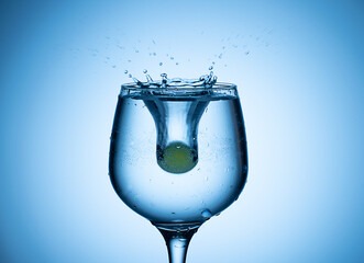 Colored ice ball droped into coctail glass .