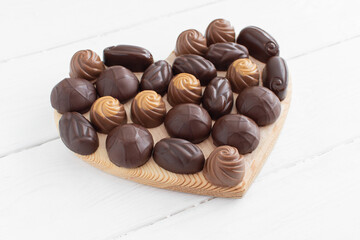 Valentine's day heart shaped box with chocolates on a white wood background. Flat lay. Valentine's day, love, gifts