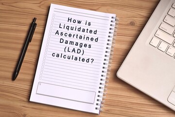 Text label on notepad with laptop on wooden table table