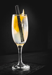 French 75 cocktail in a champagne flute on black background