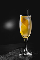 French 75 cocktail in a champagne flute on black background