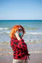 Beautiful girl with red hair on the seashore