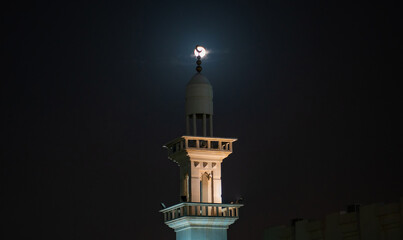 background image of mosque minaret during full moon night