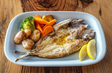 Grilled fish plate with some nicely roasted potatoes, carrots and broccoli on the side.
