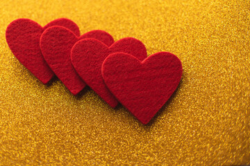 Red felt hearts on golden shiny background. Valentine's Day