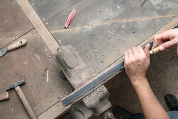 Male carpenter working on old wood in a retro vintage style.