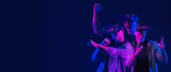Teenager having fun play VR virtual reality glasses sport game futuristic neon colorful background, future digital technology game and entertainment © DIgilife