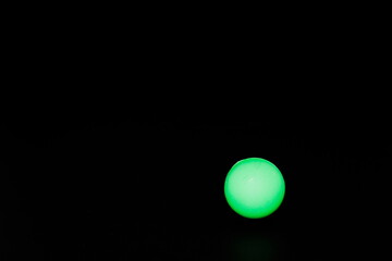 Small green ball isolated on a black background