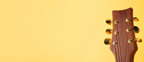 Acoustic guitar neck on a yellow background. Banner, copy space.