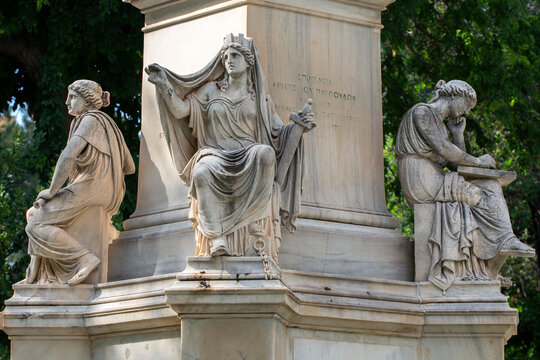 Marble statues on the base of the statue of Ioannis Varvakis in the garden of  Zappeion Palace of Athens, Greece.