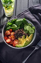 Bowl of quinoa with fresh tomato, basil, cucumber and avocado